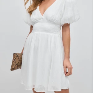 Vit klänning - Vit klänning från Gina Tricot i modellen Bow Dress.  Helt slutsåld på hemsidan. Kolla gärna in mina andra annonser, jag vill bli av med allt och ger paketpris vid köp av flera varor! Det finns just nu fri frakt under en kort tid, kontakta mig för mer info!