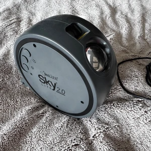 Sky Lite 2.0 - Sky Lite 2.0 förvandlar ditt rum till en galax med färgstarka stjärnor och nebulosor. Perfekt för att skapa en chill vibe, gaminghörna eller mysig filmkväll. Lätt att använda och ger en magisk känsla till alla utrymmen.