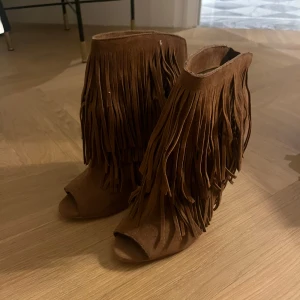 Bruna mocka boots med fransar  - Säljer ett par bruna boots i mocka med höga klackar. Superfina och bara använda 1 gång. Köpa second hand. 