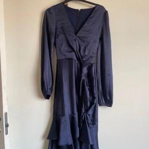 Satinklänning med volanger - Mörkblå satinklänning med volanger.