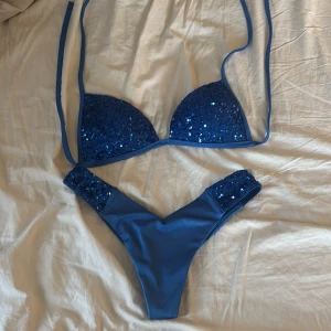 Blå paljettbikini från Calzedonia - Supersnygg blå bikini från Calzedonia, modell säljs inte längre . Aldrig använd då den inte passar mig. Skickar direkt om köpet sker innan 27 juni men ska iväg 28.