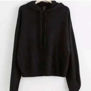 Svart stickad hoodie med huva och snörning - En svart stickad hoodie med snören. Säljer pga ingen användning! 