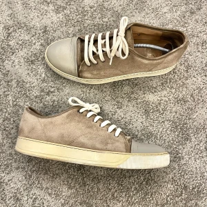 Beige Skor Från Lanvin Utan Lack - Snygga sneakers från Lanvin i beige mocka med grå tåparti i skinn och vita snören. Klassisk låg modell med rund tå och platt sula. Tillverkade i Portugal och har en stilren design som passar till det mesta. Står att skorna är storlek 11 vilket motsvarar EU storlek 45 men passar 45,5-46 då lanvins är stora i storleken. Skorna är naturligtvis äkta. Skicka gärna ett pm vid funderingar. Ny pris: 4500kr! 🤩