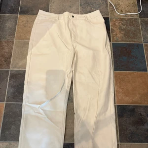 Cremevita skinnbyxor från Gina Tricot - Snygga cremevita byxor i skinnimitation från Gina Tricot. Byxorna har raka ben och en stilren look som passar perfekt till en trendig outfit. Använda fåtal gånger och är i superfint skick!!