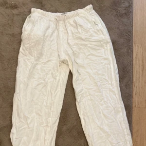 Vita linnebyxor från Gina Tricot XXS - Säljer ett par vita linnebyxor från Gina Tricot i storlek XXS. Byxorna har resår i midjan och dragsko för skön passform. De är raka i modellen och har sidfickor. Skrynkliga då dom endast legat i garderoben, knappt använda. Petite modellen som tog slut direkt.