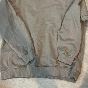 Beige sweatshirt i bomull - Tröjan är knappt använd då den legat längst bak i gaderoben och nu inte passar mig. Tröjan kommer från Lager 157 och är i storlek 140. På insidan av tröjan är den mjuk och skön mot huden. Tröjan passar till både killar och tjejer!