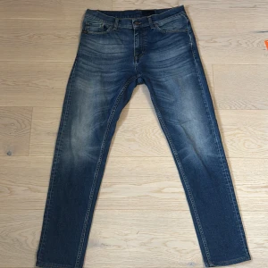 Blå jeans från Tiger of Sweden - Säljer ett par jeans från tiger of Sweden med snygg tvätt! Storlek 30/34. Hör av er vid minsta fundering! 