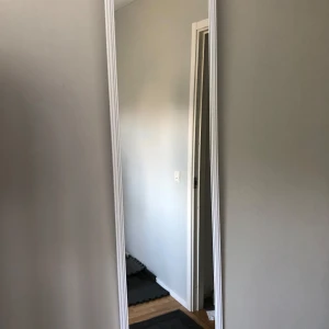 ca 1,5 meter lång spegel - säljer en spegel med vitram som har hängt i ett rum jag inte använder den är ca ett halvår gammal. (blommorna är de jag har haft på den som dekoration) ca 2 meter lång