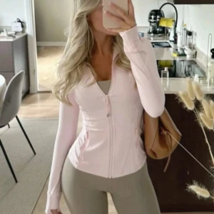 Lululemon define jacka rosa - Säljer en ljusrosa jacka från Lululemon med dragkedja framtill och figurnära passform. Jackan har länga ärmar och är tillverkad i ett mjukt, stretchigt material. Perfekt för träning eller en aktiv vardag. Helt ny! OBS storlek 2 men sitter perfekt som S, hör av vid frägor!