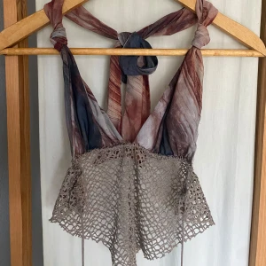 Boho linnetopp från Jaded London S - Unik linnetopp från Jaded London i storlek S. Toppen har knytband i nacken, mesh med marmorerat mönster i brunt och grått samt en beige virkad nederdel. 