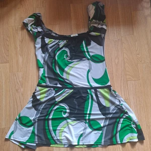 Grön mönstrad tunika  - Tunika som g från Sonic London med coolt abstrakt mönster i grönt, svart, vitt och grått. Tunikan kan vara offshoulder eller med puffärmar. Perfekt längd att ha över jeans. Väldigt svalt och strechigt material❤️😊