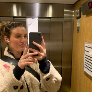 Beige teddyjacka med stora fickor - Mysig och oversized beige teddyjacka med stora framfickor och krage. Jackan har svarta knappar och en fluffig, fårullsliknande yta som ger en cool och avslappnad vibe. Perfekt för kyliga dagar och enkel att styla till det mesta.