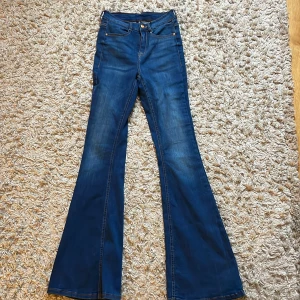 Blå bootcut jeans från Bubbleroom - Säljer ett par klassiska blå bootcut jeans från Bubbleroom. Jeansen har hög midja, utsvängda ben och femficksmodell. 