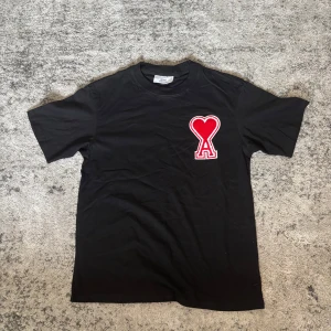Ami Paris T-shirt - En svart T-shirt med tryck på framsidan. Passar som L.