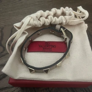 Rosa  armband med nitar från Valentino Garavani - Snyggt svart armband från Valentino Garavani med guldiga   nitar. Armbandet är gjort i skinn. Levereras med originalpåse och ask, kvitto nedkommer.