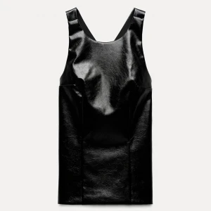 Svart zara topp i skinnimitation med korsade axelband och öppen rygg - Säljer en svart zara topp i glansig skinnimitation med öppen rygg. Toppen är oanvänd med prislappen och kvar justerbara band bak. Ny pris var 380 och tror den är slutsåld.