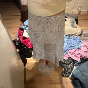 Ljusblå blommig kjol från 157 - Supersöt ljusblå kjol med blommigt mönster från 157. Kjolen har en mjuk och flowy känsla, perfekt för dig som gillar en feminin stil. Resår i midjan för extra komfort och snygg passform.