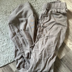 Beige mjukisbyxor från hm - Säljer ett par beige mjukisbyxor med resår i midjan och dragsko för justerbar passform. Byxorna har en avslappnad och loose fit, perfekta för chill dagar. Mjukt material som känns skönt mot huden. Från hm