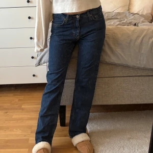 Mörkblå raka jeans - Säljer ett par klassiska mörkblå jeans med rak passform och normal midja. Jeansen har fem fickor och stängs med dragkedja och knapp. Perfekta till vardags och lätta att matcha med olika toppar.