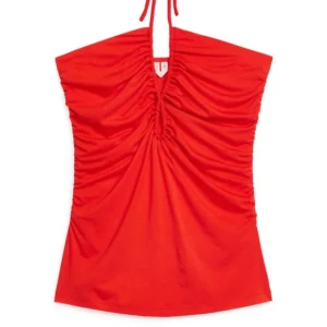Röd halterneck topp med rynkade detaljer - Säljer en snygg röd halterneck topp med rynkade sidor och v-ringning. Toppen knyts i nacken och har en figurnära passform som framhäver siluetten. Perfekt för dig som vill sticka ut med färg!