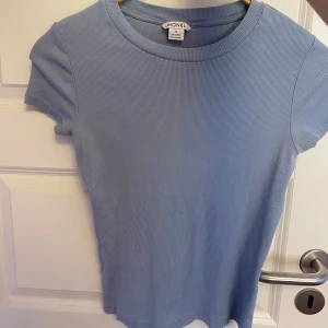 Ljusblå ribbad t-shirt från Monki - Säljer en ljusblå ribbad t-shirt från Monki. T-shirten har korta ärmar och rund halsringning. Perfekt för vår och sommar, enkel att matcha med jeans eller kjol💙🦋