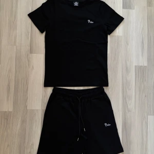 Svarta tracksuit från Timios - Vart och elegant tracksuit för sommaren perfekt för de varma vädret. Finns i storlek S, M och L