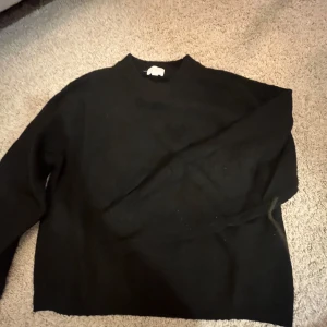 Svart stickad tröja - Svart stickad tröja med ribbad krage. Passar dig som vill något basic svart i garderoben. Inget speciellt utan en stilren mysig höst tröja. (Hm storlek xs) 