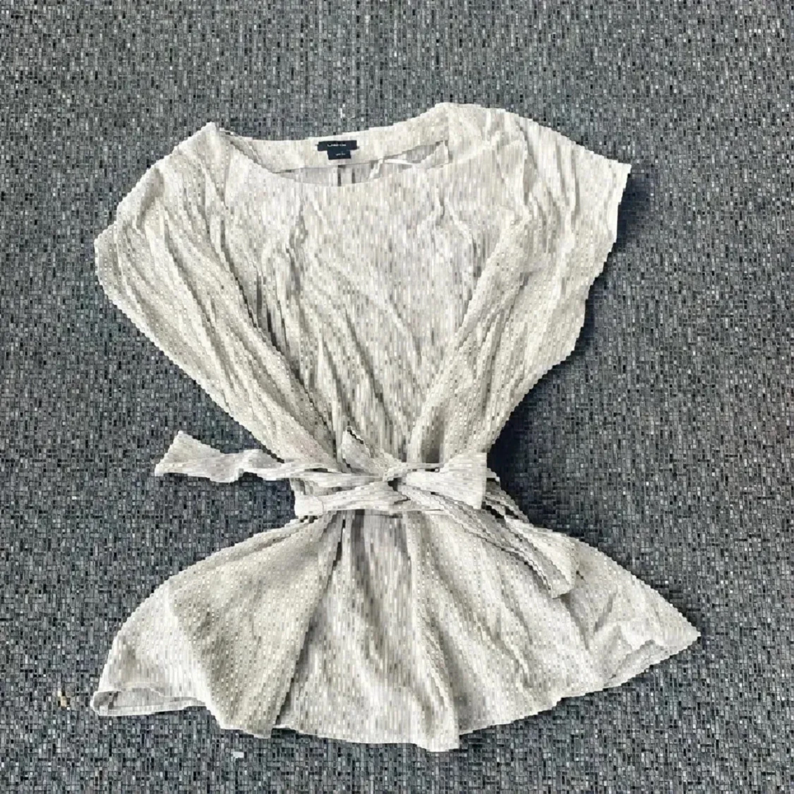 Ljus topp med knyt i midjan