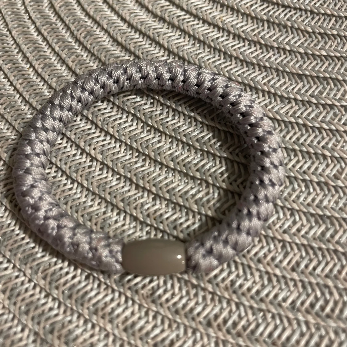 Grått flätat armband med pärldetalj