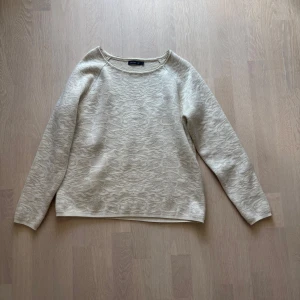 Beige stickad tröja från Stockh LM - Beige stickad tröja från Stockh LM med diskret mönster och rund halsringning. Tröjan har lång ärm och en mjuk, skön känsla som passar perfekt till jeans eller kjol. Enkel och stilren design som funkar året runt.