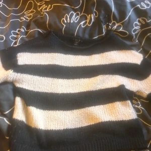 Svartvit randig stickad tröja Amisu - Säljer en snygg stickad tröja från Amisu i storlek S. Tröjan har breda svarta och vita ränder, rund hals och långa ärmar. Perfekt för dig som gillar en chill och trendig look med lite edge. Passar till jeans eller kjol för en cool vibe.