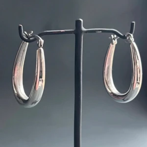 Chunky droppformade örhängen i nickelsäkert kirurgiskt stål från Lois Lane - Lätta att bära - Helt nya - butikspris 350 kr -  Eleganta droppformade örhängen från Lois Lane i kirurgiskt stål – nickelfria och skonsamma mot känslig hud. Polerad yta ger en tidlös och sofistikerad look, och den mjukt böjda formen gör dem lätta och bekväma att bära hela dagen. Perfekta för både vardag och fest. Längd: ca 3 cm. Skick: Nya/oanvända. Priset är redan lågt, så jag prutar inte – men erbjuder rabatt vid köp av flera saker. Rensar smyckesskrinet – kika på mina andra annonser!