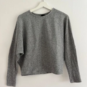 Tröja - En mjuk och fin grå ribbad tröja från Gina Tricot i lite tjockare material. Väldigt mjuk och gosig. Den är använd men ändå väldigt fin. Lite kortare i modellen.