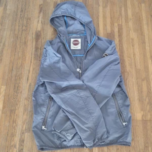 Grå vindjacka från Colmar med huva - Säljer min colmar windbreaker då jackan har blivit för liten, Storleken på jackan är 48 i Italiensk storlek men motsvarar S i vanlig storlek. Tyvärr har jag inte kvitto eller påse till Jackan men den köptes för ungefär ett år sedan och har använts fåtal gånger. Köpt för 2400 meddela mig om ni vill ha mer info😁