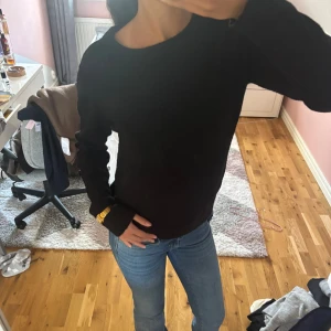 Svart stickad tröja  - En svart stickad tröja med rund hals och långa ärmar. Enkel och stilren design som funkar till jeans eller andra favoritplagg. Mjuk och skön känsla, perfekt för kyliga dagar. Passformen är normal och tröjan har inga synliga detaljer eller mönster.