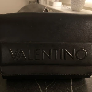 Svart axelväska från Valentino - Säljes nu en Valentino väska för Dam i väldigt bra skick använd utan några yttre eller inre slitage! Den är hel.  Säljes för 1200kr eller högstbjudande priset kan diskuteras någon hundring! Medföljes ingenting då den vart i min ägo ett tag Finns i Stockholm! Mvh hör av dig för mer info 