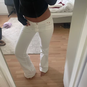 Vita flare jeans  - Säljer ett par vita jeans från H&M Flare i modellen med regular waist och utsvängda ben. Snygg passform med klassiska fickor och kopparfärgade detaljer. Jag är 170cm, och de är långa på mig!