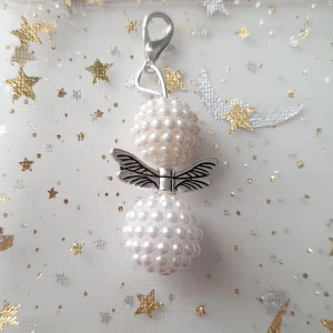 Vit smyckesängel/lyckoängel  - Unik ängel gjord av vita pärlor och silverfärgade vingar. Hängsmycket har en rund form och fästs med en karbinhake. Perfekt för dig som gillar söta och personliga smycken med lite magisk känsla. Handgjord av mig
