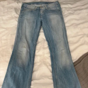 Lowwaist bootcut Pepe jeans - Snygga bootcut ljusblå jeans från Pepe Jeans. Jeansen har slitna detaljer och en tvättad look som gör dom skit snygga på! Så så snygga jeans älskar super mycket men passade tyvärr inte☹️☹️fick hem dem idag från vinted, bilderna är lånade från förra ägaren🩷🩷midjemåttet är 37cm och inerbenslängden 75cm