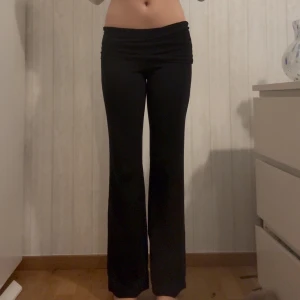 Svarta yogapants med låg midja - Säljer ett par svarta bootcut byxor med låg midja och stretchigt material. De har en snygg, figurnära passform upptill och släpper ut vid benen för en trendig siluett. Perfekta för dig som gillar en stilren och bekväm look. Skriv privat för mer bilder!💕💕 lappen sitter fortfarande på fick i julklapp. Kan tänka mig gå ner i pris vid snabb affär