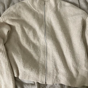 Beige stickad kofta med dragkedja XL - Säljer en beige stickad kofta från 157 i storlek XL. Koftan har hög krage, lång ärm och hel dragkedja framtill. Den är ribbstickad och har en loose passform, perfekt för lager-på-lager under höst och vinter.