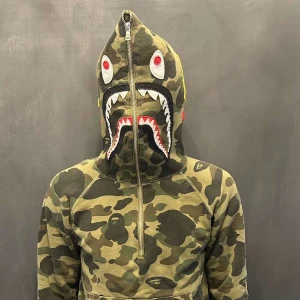 BAPE Shark Hoodie Camouflage - Säljer en ikonisk BAPE Shark hoodie i grön camouflage med broderade detaljer och half zip. Köpt i USA, såklart äkta. Pris kan diskuteras.