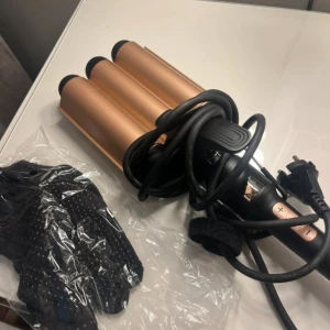 Wave Iron locktång svart/rosé - Wave Iron locktång i svart och rosé med tre stora cylindrar (32 mm) för att skapa snygga beach waves. Digital display, justerbar temperatur (100-200°C) och automatisk avstängning. Värmeskyddande handske medföljer. Sladdlängd 2,5 meter.