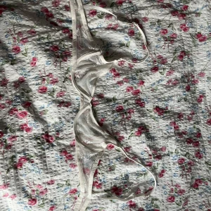 Vit spets bh - Aldrig anväbd då den var för liten. A-cup. Säljer en superfin vit bh med tunna axelband och transparent spetsdetaljer. Toppen har meshpartier och vacker broderad spets framtill. Justerbara band. 