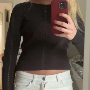 Mörk grön croppad stickad tröja Monki - Säljer en mörk grön  croppad stickad tröja från Monki i storlek M. Tröjan har lång ärm och snygga hålstickade detaljer längs ärmar och mitt fram. Perfekt att styla med höga jeans för en chill look.