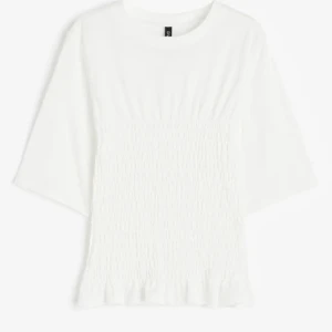 Vit smockad blus med volangkant - Supersöt vit blus med smockad midja och volangkant nertill. Jätte populär så köp snabbt finns ej längre att köpa i butik/nätet!! ❣️ aldrig använt 