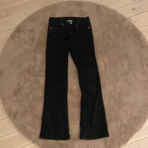 Svarta bootcut jeans från Kappahl - Snygga svarta jeans från Kappahl i storlek 158. Modellen har bootcut-ben och klassisk femficksdesign. Jeansen är i stretchigt material som sitter skönt och har en tidlös look som passar till det mesta.