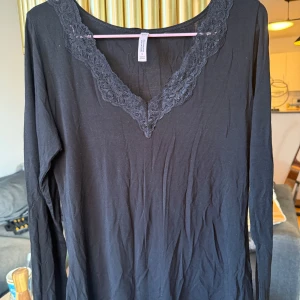 HUNKEMÖLLER svart långärmad topp med spetskant vid halsen - Aldrig använd, enbart provad. Normal i storleken, tight passform. Mycket stretchigt material. Tunnt tyg men ej genomskinligt.   Påminner om Intimissimis populära ultralight-tröjor!