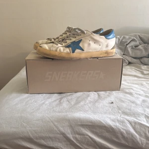 Golden Goose Superstar sneakers vit/blå - Säljer ett var vita Golden Goose med blå stjärna! Sparsamt använda med tecken av användning. Men redo att ge mer!