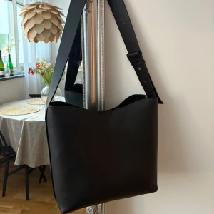 Svart axelväska - Väska från Lindex inköpt förra hösten inför skolstart, men tyvärr rymmer den inte min dator. Den är iprincip oanvänd då jag försökte ge den en chans utan dator men den har mest hängt på en krok sen jag köpte den😌